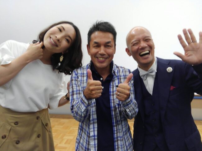 受講生と並び、笑顔で手を振る鴨頭嘉人