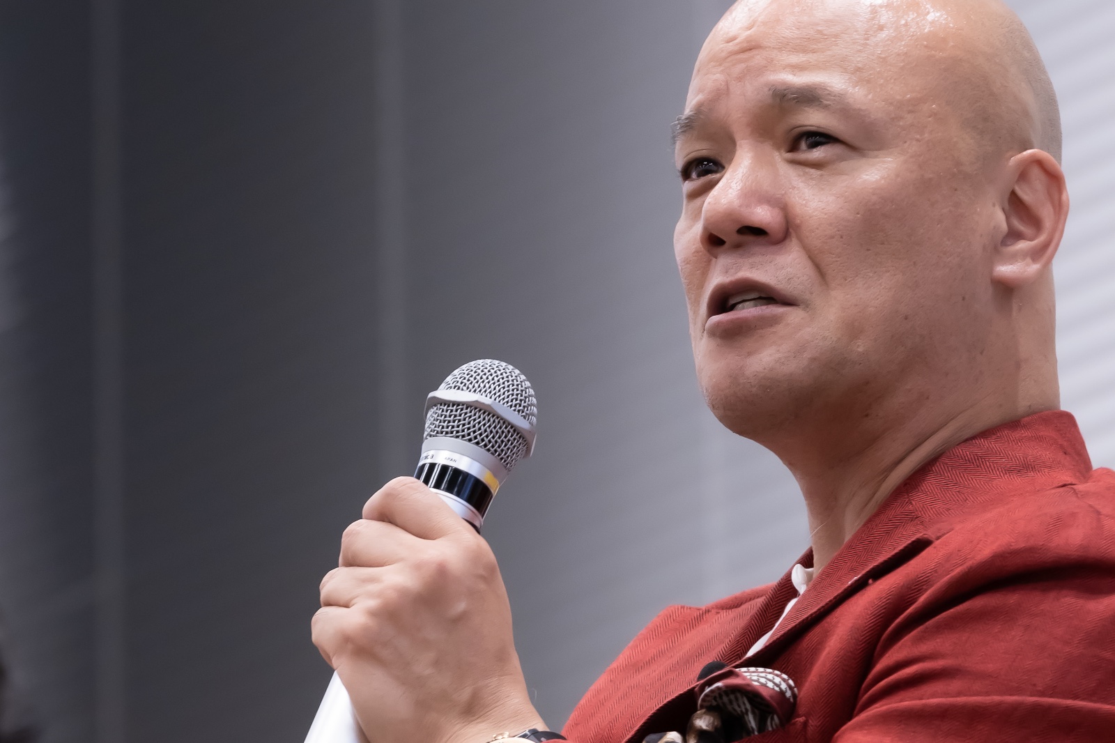 マイクを持って聞き手へ語りかける鴨頭嘉人