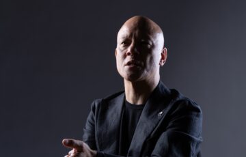 暗い背景で未来を見据えながら語る鴨頭嘉人