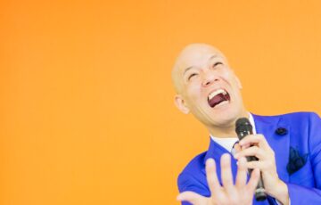 青いスーツ姿で表情豊かに自分の言葉を語る鴨頭嘉人