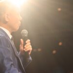 照明の差すステージで話し始める鴨頭嘉人