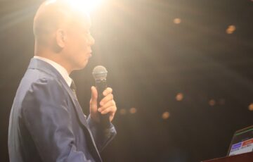 照明の差すステージで話し始める鴨頭嘉人