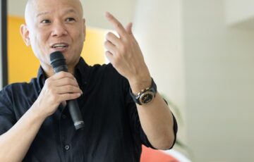 マイクを持ち、相手へ問いかけるように話す鴨頭嘉人
