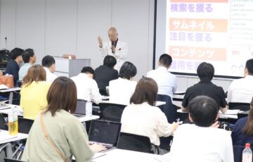 大勢の受講生が参加する講座で話す鴨頭嘉人