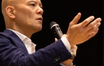講演で手を差し出しながら聴衆へ語りかける鴨頭嘉人